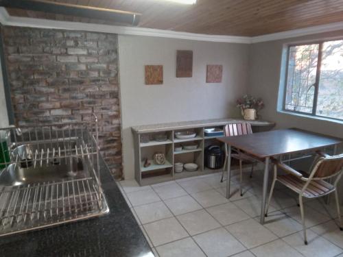 Dinokeng Game ReserveHartbees Boskamp的厨房配有桌椅和砖墙