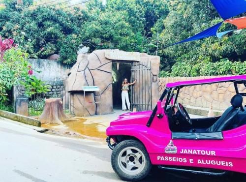 圣米格尔-杜斯米拉格里斯Casa Milagres do Porto - Suítes的长颈鹿前停的粉红色汽车