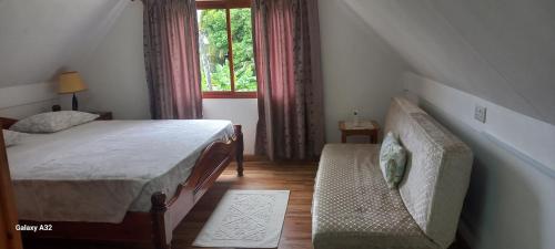 安塞奥潘爱巢自助式旅馆的一间卧室配有一张床、一张沙发和一个窗口