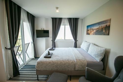 Ban Tha FatMantra Beach Condominium Suite 2 - Mae Phim的酒店客房设有一张床和一个阳台。