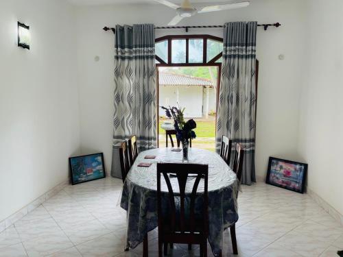 卡卢特勒Pasidu Villa的一间带桌椅和窗户的用餐室