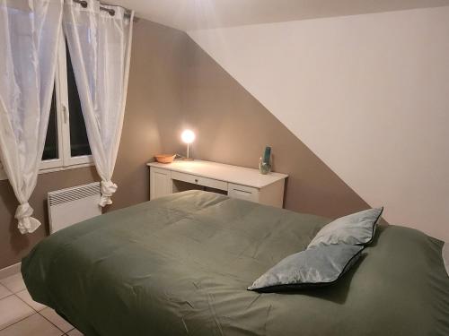 尼姆Maison tout confort的一间卧室设有一张带倾斜天花板的绿色床