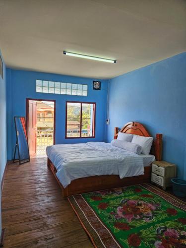 Muang PakxongPaksong Brand New- Two-story house的一间卧室设有一张床和蓝色的墙壁