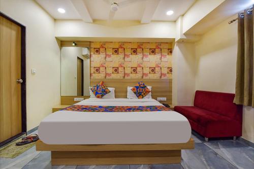 艾哈迈达巴德FabHotel Vishala的一间卧室配有一张大床和一张红色的沙发