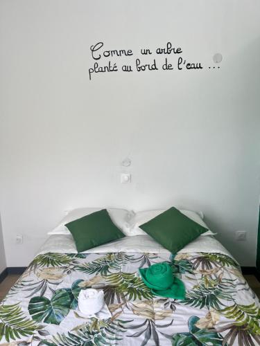 勒唐蓬La Maison Verte的卧室配有一张挂有墙上标志的床