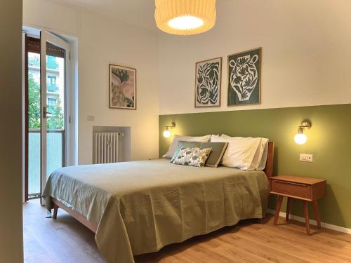 米兰Luxury 2 bedroom Apartament, close to San Siro, Fiera and 10 min metro to Duomo的一间卧室配有一张带绿色墙壁的床