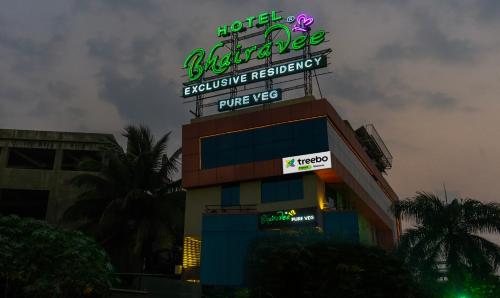浦那Treebo Trend Bhairavee - Baner的上面有 ⁇ 虹灯标志的建筑
