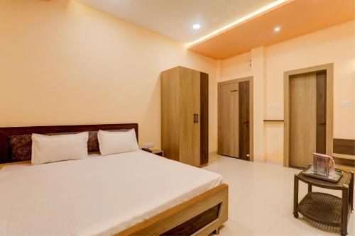 巴特那OYO Hotel Ambika Palace的一间卧室配有一张大床和一张桌子