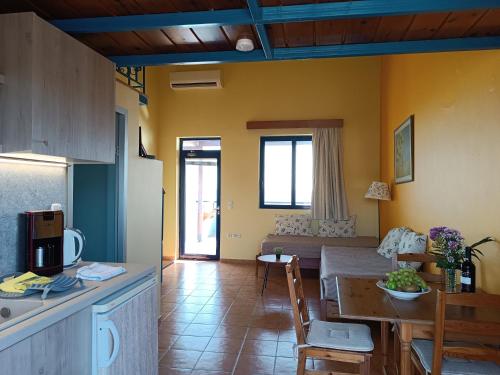 吉奥塔略Paraktio Beach Apartments的厨房以及带桌子和沙发的客厅。