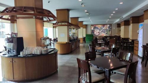 拉差汶里Western Grand Hotel Ratchaburi (SHA Extra Plus)的一间带桌椅的餐厅和一间酒吧