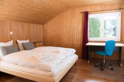 伦策海德Ferienhaus Tgantieni Ski-in Ski-out-Lenzerheide的一间卧室配有一张床、一张桌子和一把椅子