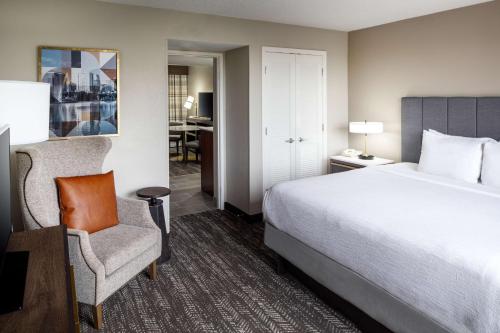 奥兰多Embassy Suites by Hilton Orlando North的配有一张床和一把椅子的酒店客房