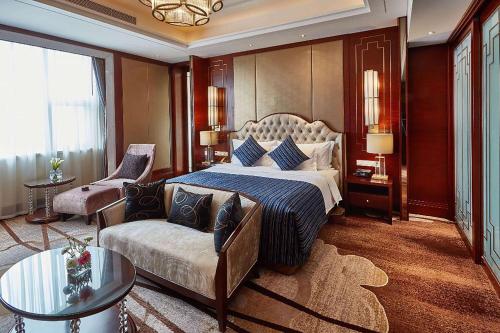荆州荆州南国温德姆酒店的一间卧室配有一张特大号床和一张沙发