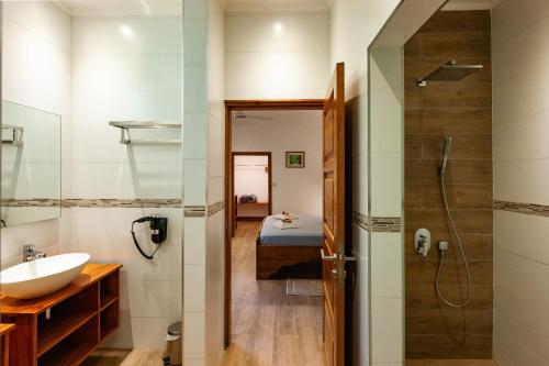 昂斯拉齐奥Anse Lazio Lodge的一间带水槽和淋浴的浴室以及一张床