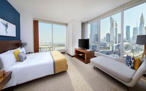 迪拜voco Dubai, an IHG Hotel的大型酒店客房设有一张大床和一张沙发。