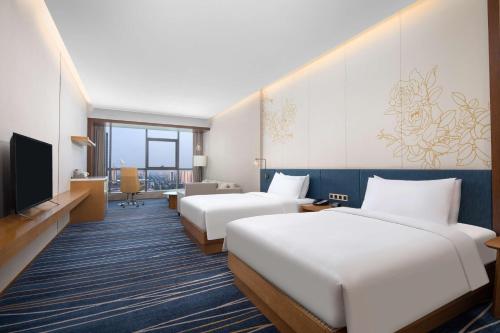 淄博淄博鼎成希尔顿花园酒店的酒店客房设有两张床和电视。