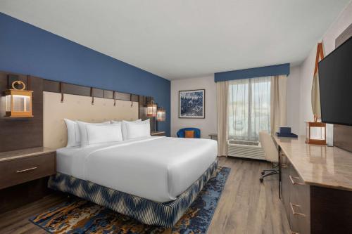 堪萨斯城Hotel Westport Kansas City, Tapestry Collection by Hilton的酒店客房设有一张大床和一张书桌。