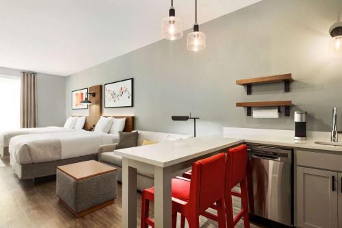 劳雷尔山Hawthorn Extended Stay by Wyndham Mount Laurel Moorestown的酒店客房设有一张床和一个带桌子的厨房
