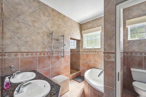 豪特湾Seaside Villa - 1 La Mer的一间带两个盥洗盆、浴缸和卫生间的浴室