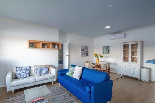 SaratogaCentral Coast Jetty House的客厅配有蓝色的沙发和桌子