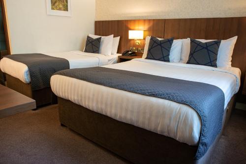 阿克洛Arklow Bay Hotel的酒店客房,设有两张床和一盏灯