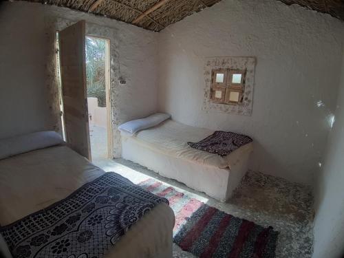 锡瓦M Biama Island的带窗户的客房内的两张床