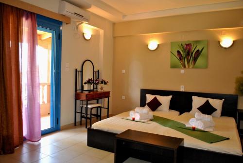 米提卡斯Iliovasilema Hotel的一间卧室配有一张床、一张桌子和一个窗户。