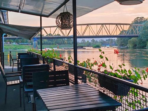 丘普里亚Cruiser restoran的河畔的餐厅,配有桌椅
