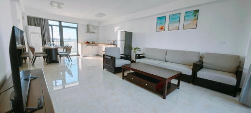 南迪Ocean Breeze Apartment的带沙发和桌子的客厅以及厨房。