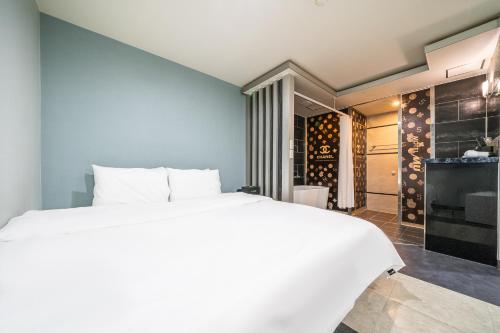 釜山MU HOTEL的卧室配有白色的床和酒窖。