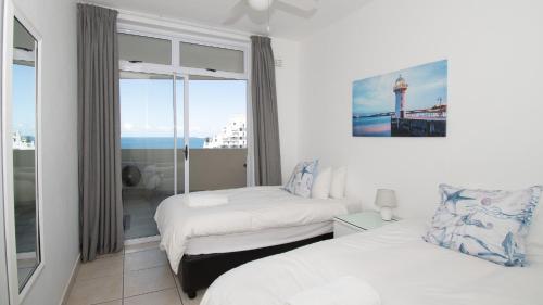 德班72 Sea Lodge Umhlanga Rocks的酒店客房设有两张床和窗户。