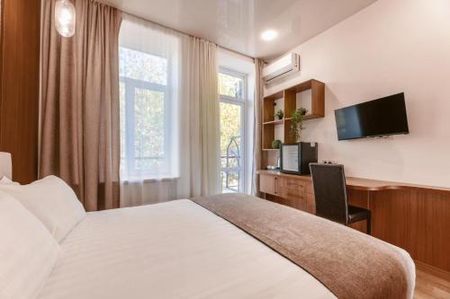 茨卡尔图博Park Hotel Tskaltubo - Balneo Resort的一间卧室设有一张床、一台电视和一个窗口。