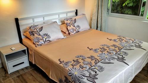 塔卡马卡Dovass Self Catering Apartments的卧室内的一张床铺,床上有鲜花床罩