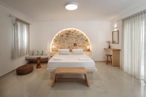 阿吉奥斯普罗科皮奥斯Proteas Hotel & Suites的一间卧室配有一张床、一张沙发和一张桌子
