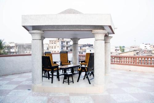 科托努Magnifique Appartement - Cotonou - Avotrou Apkapka的屋顶上配有桌椅的凉亭