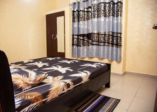 科托努Magnifique Appartement - Cotonou - Avotrou Apkapka的卧室,卧室配有床,卧室配有窗帘