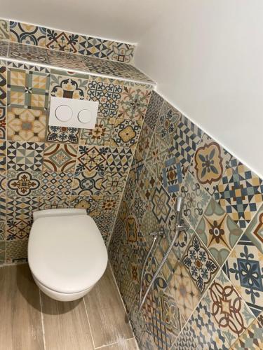 戈内斯Villa Houria的浴室设有卫生间,墙上铺有瓷砖。