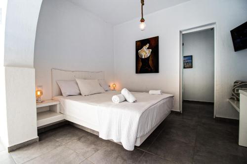 纳乌萨米卡别墅酒店的卧室配有白色的床和2条毛巾