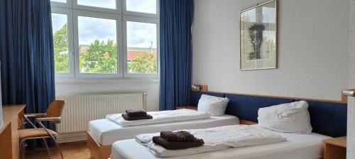 柏林豪斯尼德菲尔德HW酒店 的酒店客房设有两张床和窗户。