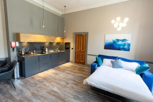 爱丁堡MONO Suites NEW TOWN的一间带蓝色床的卧室和一间厨房