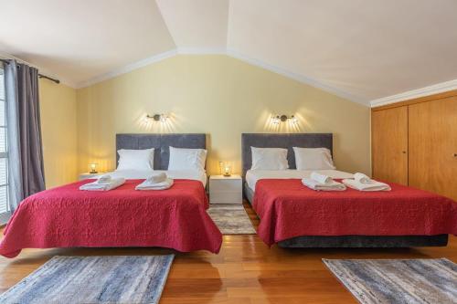 卡尼索flowers island house 4的两张床铺,房间配有两张红色床单