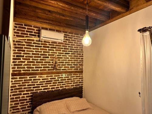 迪亚巴克尔Karga Butik Otel的一间设有砖墙、一张床和一盏灯的房间