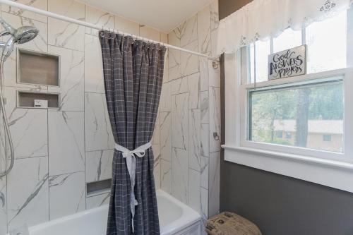 格林维尔House Near Bju, Furman, & Town的浴室配有淋浴帘和浴缸。