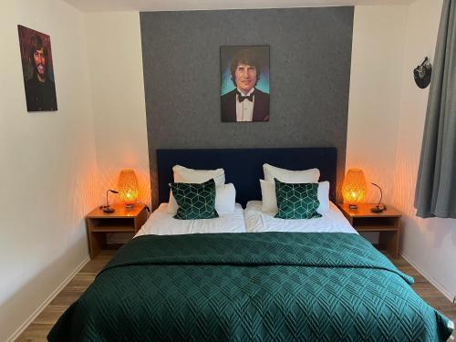 锡默拉特奥伯斯酒店的一间卧室配有一张带绿毯的床和两盏灯。