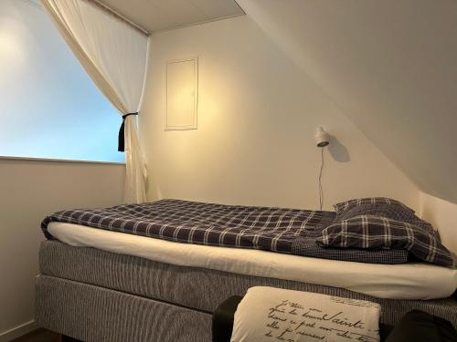 英斯约Yngsjövång的一个小房间的一个床位,设有窗户