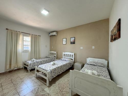 福尔摩沙La Pilar的一间卧室设有三张床和窗户。