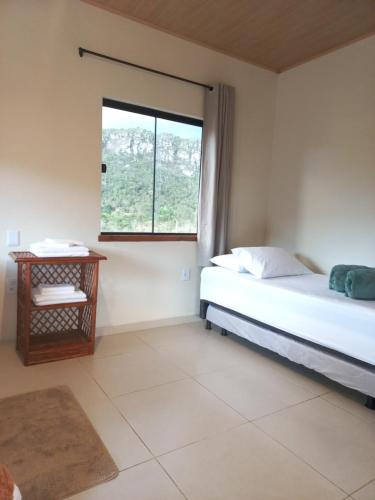伊比科阿拉Recanto Cachoeiras de Ibicoara的一间卧室设有一张床和一个窗口