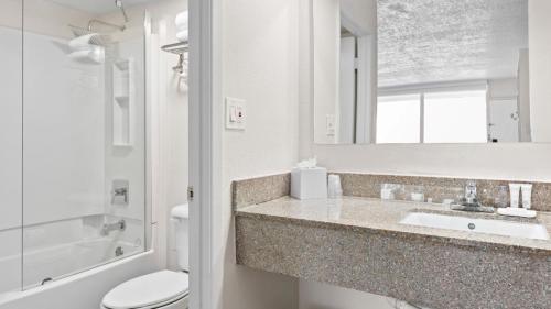 杰克逊维尔Developer Inn & Suites Airport JAX, a Baymont by Wyndham的一间带水槽、卫生间和镜子的浴室