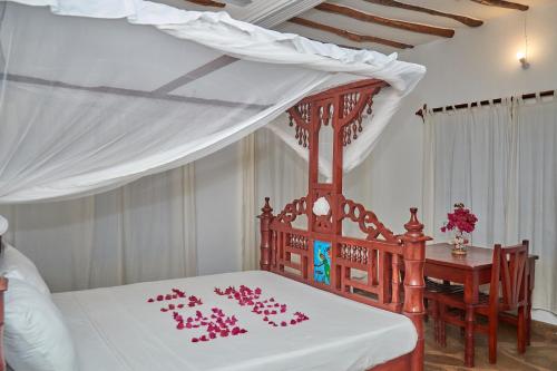 马林迪Beach Way Villa的一间卧室配有一张粉红色装饰的床。