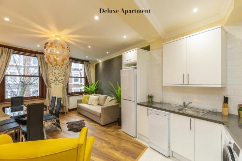伦敦Stylish Apartment Kensington的厨房以及带沙发和桌子的客厅。